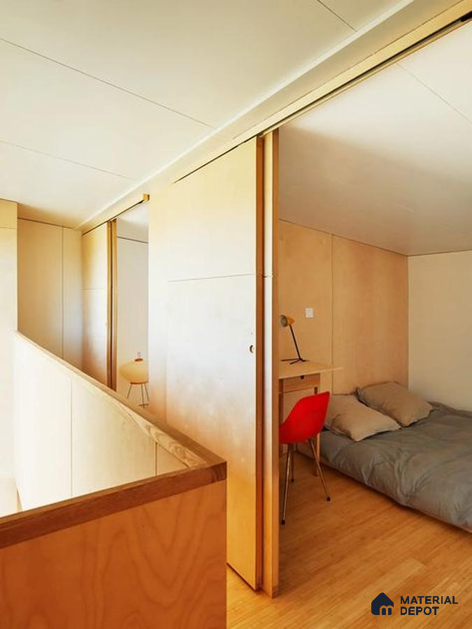 A bathroom with a large tub in the middle of it and wooden flooring next to a white tiled walls and white bathtub in front of a window with lots of a wooden table next to a large window